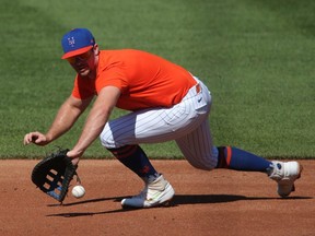 New York Mets first baseman Pete Alonso (20) makes a sliding stop of a ground ball during a simulated game at Citi Field.