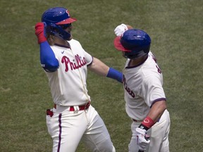 Phillies' Bryce Harper, left, celebrates with J.T. Realmuto after hitting a three run home run in the bottom of the first inning against the Marlins at Citizens Bank Park in Philadelphia, Sunday, July 26, 2020.