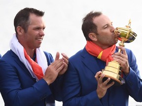 Europe's Spanish golfer Sergio Garcia (right) kisses the trophy alongside Europe's English golfer Paul Casey (left) as they celebrate winning the 42nd Ryder Cup at Le Golf National Course at Saint-Quentin-en-Yvelines, south-west of Paris, Sept. 30, 2018.