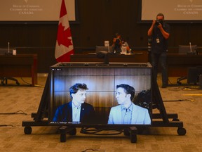 Marc Kielburger, screen left, and Craig Kielburger, screen right, appear as witnesses via videoconference during a House of Commons finance committee in the Wellington Building in Ottawa on Tuesday, July 28, 2020.