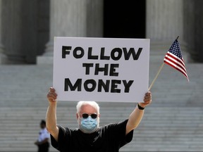 Demonstrator Bill Christeson holds a sign outside the U.S. Supreme Court in Washington, July 9, 2020.