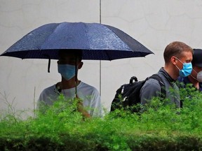 People wearing face masks leave the U.S. Consulate General in Chengdu, Sichuan province, China, July 25, 2020. REUTERS/Thomas Peter ORG XMIT: GDN
