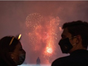 White House guests wearing protective face masks due to the coronavirus disease (COVID-19) pandemic watch the Washington, D.C. fireworks display from the South Lawn of the White House as they celebrate the U.S. Independence Day holiday in Washington, U.S., July 4, 2020.   REUTERS/Carlos Barria ORG XMIT: WAS441