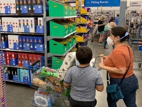 Customers wearing masks shop at a Walmart store, in compliance with a state-ordered requirement for facial coverings, July 17, 2020 in Burbank, California.