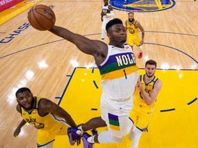 New Orleans Pelicans forward Zion Williamson (1) dunks against Golden State Warriors forward Eric Paschall (7) and centre Dragan Bender (10) at Chase Center.