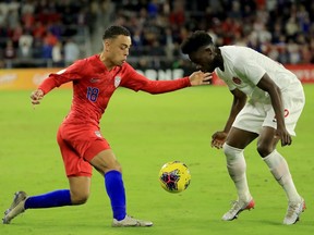 Sergino Dest of the United States, left, attempts to drive past Alphonso Davies of Canada during the CONCACAF Nations League match at Exploria Stadium in Orlando, Florida on November 15, 2019. The road to the 2022 FIFA World Cup in Qatar has been set for Canada with the CONCACAF preliminary qualifying draw taking place on Wednesday, Aug. 19 in Zurich, Switzerland.