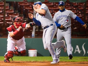 Boston Red Sox's Christian Vazquez, left, tags out Travis Shaw of the Toronto Blue Jays at home plate in the sixth inning at Fenway Park on August 8, 2020 in Boston, Mass.