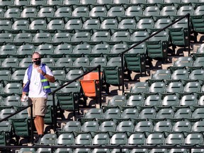 A member of the Major League Baseball Authentication Program collects baseballs in the outfield before the start of the Baltimore Orioles and New York Yankees game at Oriole Park at Camden Yards on July 29, 2020 in Baltimore, Maryland.