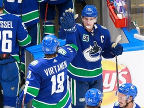 Bo Horvat and Jake Virtanen celebrate a 4-3 victory Tuesday.