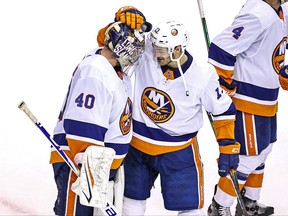 Semyon Varlamov, left, is congratulated by his teammate, Mathew Barzal after his 2-0 shutout victory against the Washington Capitals in Game 5 to win the Eastern Conference First Round during the 2020 NHL Stanley Cup Playoffs at Scotiabank Arena on Aug. 20, 2020 in Toronto.