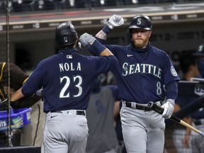 Jake Fraley congratulates Austin Nola of the Seattle Mariners after his solo homerun during the sixth inning of a game against the San Diego Padres at PETCO Park on August 25, 2020 in San Diego, California.