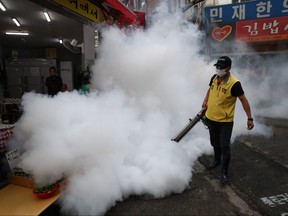 A worker disinfects an alley to prevent the coronavirus spread on August 29, 2020 in Seoul, South Korea.