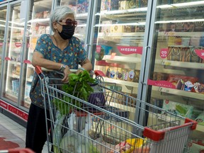 A woman looks at frozen food products in a supermarket following an outbreak of the coronavirus disease (COVID-19) in Beijing, China, Aug. 13, 2020.