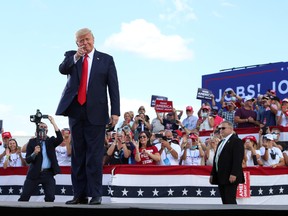 U.S. President Donald Trump gestures in front of supporters at Basler Flight Service in Oshkosh, Wisconsin,  Aug. 17, 2020.
