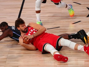 Orlando Magic forward James Ennis III and Toronto Raptors center Marc Gasol go after a loose ball in the first half last night at the Visa Athletic Center.