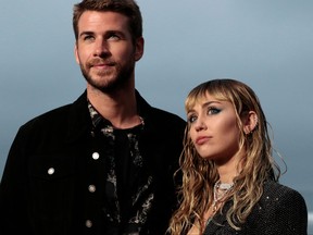 In this file photo taken on June 6, 2019, US singer Miley Cyrus and husband Australian actor Liam Hemsworth arrive for the Saint Laurent Men's Spring-Summer 2020 runway show in Malibu, California.