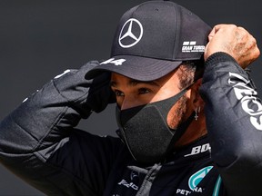 Mercedes' British driver Lewis Hamilton reacts after finishing first in the qualifying session for the Formula One British Grand Prix at the Silverstone motor racing circuit in Silverstone, central England on Aug. 1, 2020.