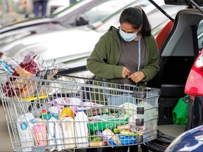 A face mask-clad shopper packs groceries in the suburb of Takapuna in Auckland, New Zealand on Aug. 12, 2020.