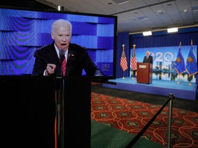U.S. Democratic presidential candidate and former Vice President Joe Biden appears on a screen as Convention Co-Chair and Milwaukee Mayor Tom Barrett (back) opens the second night of the Democratic National Convention, being held virtually amid the novel coronavirus pandemic, at its hosting site in Milwaukee, Wisconsin, on Aug. 18, 2020.