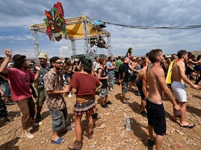 In this file photo taken on Aug. 10, 2020 people dance and attend a rave party, on an agricultural land in Causse Mejean, in the heart of the Cevennes National Park, southern France, despite the limitation of gatherings linked to COVID-19, the novel coronavirus.