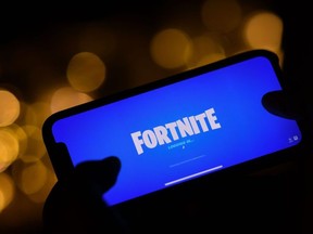 This file illustration photo taken on August 14, 2020 shows a person logging into Epic Games' Fortnite on their smartphone in Los Angeles.
