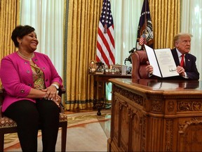 U.S. President Donald Trump displays Alice Johnson's full pardon in the Oval Office of the White House in Washington, D.C., on Friday, Aug. 28, 2020.