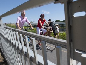 Infrastructure and Communities Minister Catherine McKenna and Velo Canada Bikes Executive Director Brian Pincott ride bicycle's to a news conference along the Rideau canal, in Ottawa, Thursday, Aug. 13, 2020.