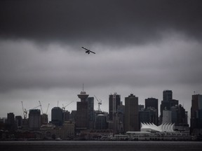 A seaplane takes off from the harbour under low cloud above the downtown skyline, in Vancouver, Thursday, Aug. 6, 2020.