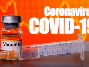 A small bottle labelled with a "Vaccine" sticker stands near a medical syringe in front of displayed "Coronavirus COVID-19" words in this illustration taken April 10, 2020. /Photo ORG XMIT: FW1