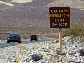 A sign warns of extreme heat as tourists enter Death Valley National Park in California June 29, 2013.