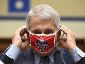 Anthony Fauci, director of the National Institute of Allergy and Infectious Diseases, removes his Washington Nationals mask during a House Select Subcommittee on the Coronavirus Crisis hearing on July 31, 2020 in Washington.