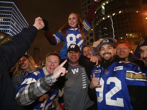 Winnipeg Blue Bomber fans celebrate winning the 107th Grey Cup over the Hamilton Tiger Cats at the intersection of Portage and Main in Winnipeg on November 24, 2019.