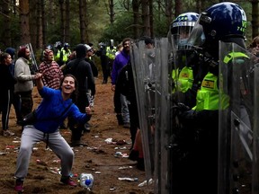 A reveller gestures in front of police at the scene of a suspected illegal rave in Thetford Forest, Britain, August 30, 2020.
