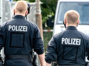 Policemen walk past their vehicles in the northern German city of Hanover on July 29, 2020.