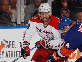 Mike Green of the Washington Capitals is checked by Thomas Hickey, right, of the New York Islanders in Game 6 of the Eastern Conference Quarterfinals during the 2015 NHL Stanley Cup Playoffs at the Nassau Veterans Memorial Coliseum on April 25, 2015 in Uniondale, N.Y.