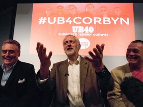 British opposition Labour Party leader Jeremy Corbyn (C), sits alongside members of the the British band UB40, including, Duncan Campbell (R), and Brian Travers, as the band announce their support for him in the ongoing Labour Leadership contest, at a press conference at the RSA in central London on September 6, 2016.