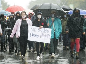 People attend a demonstration in Montreal, Saturday, Aug. 29, 2020, where they protested to defund the police with a goal to end all systemic racism within all sectors of the Canadian government.