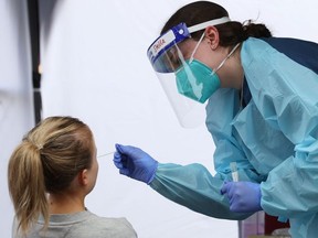 A medical worker administers a test for the coronavirus disease (COVID-19) on a member of the public at a pop-up testing centre in Sydney, Australia, August 12, 2020.
