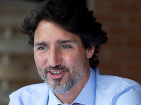 Canada's Prime Minister Justin Trudeau speaks with local business owners at a bistro in his Papineau riding in Montreal, Quebec, Canada August 31, 2020.