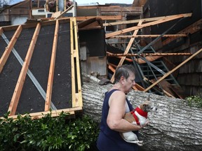 Kathy Shamburger gathers what she can from her first floor apartment that was damaged after Hurricane Laura passed through the area in Lake Charles, Louisiana, Thursday, Aug. 27, 2020.