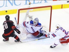 Rangers goalie Henrik Lundqvist makes a save against Hurricanes forward Sebastian Aho in Game 2 of their qualifier. GETTY IMAGES