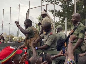 Malian soldiers are celebrated as they arrive at the Independence square in Bamako on August 18, 2020.