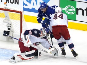 Blue Jackets goalie Joonas Korpisalo stops a shot as Maple Leafs centre Auston Matthews looks for a rebound as Columbus defenceman Vladislav Gavrikov fends him off during Game 1 of their Eastern Conference qualifier on Sunday.