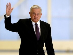 Mexico's President Andres Manuel Lopez Obrador waves as he arrives to hold a news conference at the presidential hangar t Benito Juarez International Airport in Mexico City, Mexico July 27, 2020.