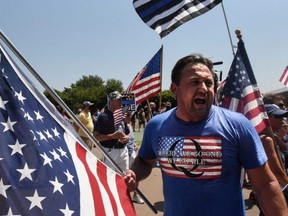 A person wearing a t-shirt supportive of QAnon conspiracies participates in a "Back the Blue" rally in the Brooklyn borough of New York City, Aug. 9, 2020.