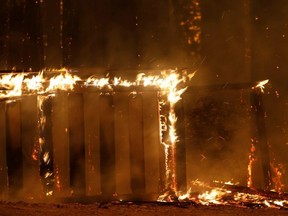 A burning fence is seen along Empire Grade during the CZU Lightning Complex Fire on the outskirts of Santa Cruz, Calif., Thursday, Aug. 20, 2020.