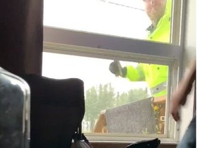 A Royal Mounted Police Officer punches a window during a wellness check in Stanley Mission, Sask., in this recent screengrab taken from video.
