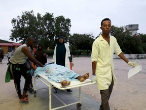 Paramedics and civilians carry an injured person on a stretcher at Madina hospital after a blast at the Elite Hotel in Lido beach in Mogadishu, Somalia August 16, 2020.