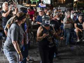 Maggie Zepeda, centre, dances as she watches a concert at the Full Throttle Saloon during the 80th Annual Sturgis Motorcycle Rally in Sturgis, South Dakota Aug. 9, 2020.