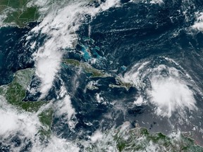This image obtained from the National Oceanic and Atmospheric Administration (NOAA) shows Tropical Storm Laura over Puerto Rico and approaching Haiti; and Tropical Storm Marco between Cuba and the Yucatan Peninsula, captured Saturday, Aug. 22, 2020.
